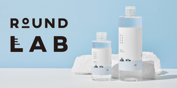 ROUND LAB: dwa tonery w przezroczystych butelkach (mała i duża), z minimalistycznymi etykietami na błękitnym tle.