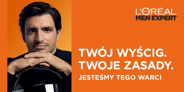 Carlos Sainz Jr., ambasador L'Oréal Men Expert, patrzy na wprost, opierając ręce na kasku. Pomarańczowe tło, slogan.
