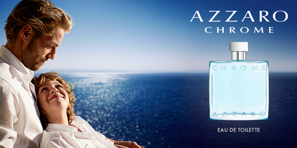 Azzaro Chrome Eau de Toilette w kwadratowej butelce z jasnoniebieskim płynem, obok ojca z synem nad oceanem.