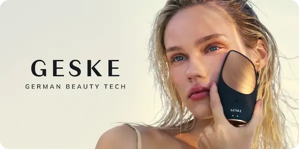 Kobieta z blond włosami trzyma czarno-miedziane urządzenie GESKE German Beauty Tech na policzku.