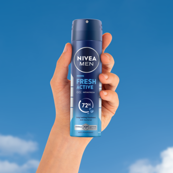Niebieski antyperspirant NIVEA Men Fresh Active w sprayu z tekstem '72h' i 'INFINIFRESH', trzymany w dłoni na tle błękitnego nieba.
