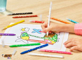 Dziecko koloruje rysunek samolotu wymazywalnymi flamastrami Bic Kids (10+2 wymazywacze) na drewnianym stole.