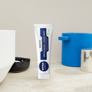 Biała tuba NIVEA MEN Sensitive Łagodzący Krem do Golenia 100ml, dla skóry wrażliwej, widok frontalny na blacie.