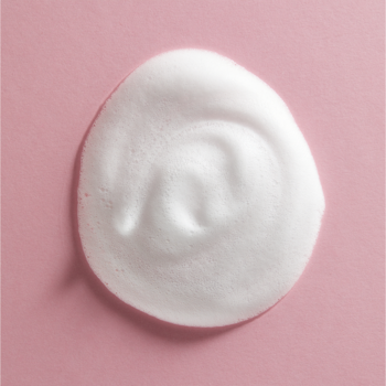 Biała, puszysta piana NIVEA do oczyszczania twarzy z ekstraktem z migdała na różowym tle, widok z góry.