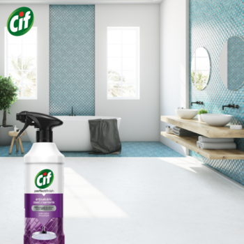 Fioletowy spray Cif Ultra Hygienic z czarnym spustem, na białej podłodze nowoczesnej łazienki.