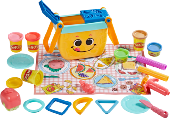 Play-Doh Piknikowa Zabawa, wiaderko z uśmiechem, foremki, narzędzia i różnokolorowa masa plastyczna na kocu.