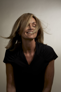 Szampon zagęszczający PROfiller+. Uśmiechnięta kobieta z burzą blond włosów, symbolizującą objętość i siłę.