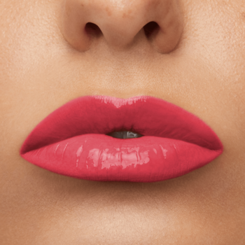 Zbliżenie na usta z pomadką Maybelline Super Stay Vinyl Ink Rogue, intensywny koralowy róż o winylowym połysku.
