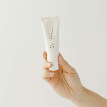 Krem SPF 50+ Beauty of Joseon Relief Sun Rice + Probiotics w jasnej tubce, trzymany w dłoni na białym tle.