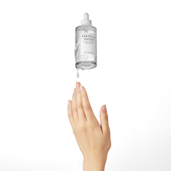 Serum rozjaśniające Centella Asiatica, przezroczysta butelka z pipetą, kropla spada na otwartą dłoń.