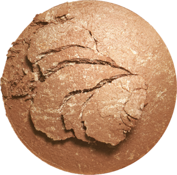Okrągły, perłowy bronzer Revolution Reloaded w odcieniu Long Weekend, widok z góry, z widocznymi pęknięciami.