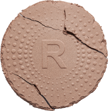 Zbliżenie na jasnobrązowy, matowy Revolution Mega Bronzer z wytłoczoną literą R i widocznymi pęknięciami.