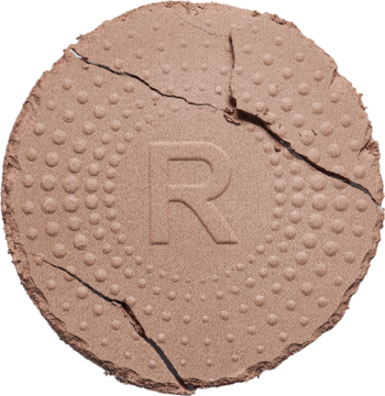 Zbliżenie na jasnobrązowy, matowy Revolution Mega Bronzer z wytłoczoną literą R i widocznymi pęknięciami.