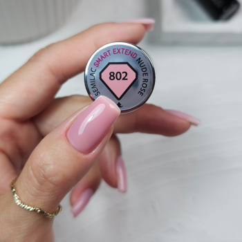 Zbliżenie na srebrną nakrętkę lakieru Semilac Smart Extend 802 Nude Rose, dłoń z jasnoróżowymi paznokciami.