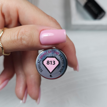 Zbliżenie na nakrętkę lakieru Semilac Smart Extend 813 Pastel Pink, trzymaną w dłoni z różowymi paznokciami.