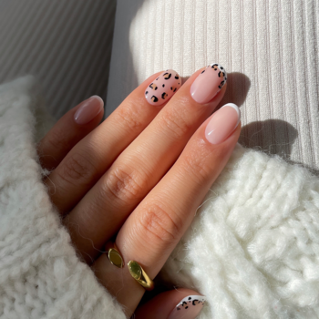 Manicure Semilac Smart Extend 816 na dłoni, biały sweter: French i paznokcie w cętki leoparda.