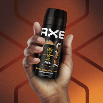 Dezodorant Axe Dark Temptation Limited Edition, czarna butelka z logo i złotym pucharem FIFA, trzymany w dłoni, przodem.