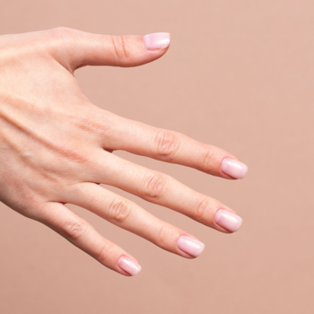 Semilac Skin Tone Cover Base, naturalny manicure na dłoni, paznokcie w mlecznym różu. Widok z góry.