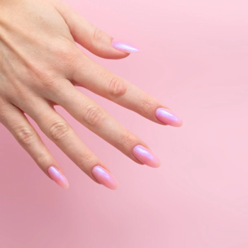 Kobieca dłoń z migdałowymi paznokciami, lśniącymi lakierem Semilac Blue Glazed. Półprzezroczysty róż z efektem Glazed Nails.