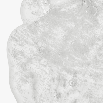 Zbliżenie na przezroczysty, wygładzający żel do mycia ciała z kwasami AHA BHA PHA, z widocznymi bąbelkami powietrza.