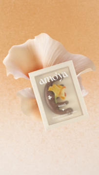 Amo'ya drewniany grzebień do masażu skóry głowy i ciała, w opakowaniu z grafiką kwiatu, na pastelowym tle.