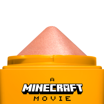 NYX Rare Highlight Balm A Minecraft Movie: zbliżenie na otwarty pomarańczowy sztyft z brzoskwiniowym rozświetlaczem.