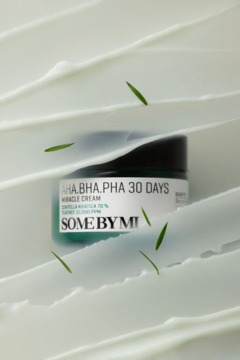 Krem Some By Mi AHA.BHA.PHA 30 Days Miracle, zielony słoiczek na tle białych fal kremu z drobnymi listkami.