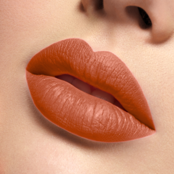 J.Cat Beauty Lip Lock Essential: zbliżenie ust z matową pomadką w płynie w odcieniu terakotowo-koralowym.