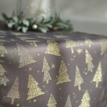 Ciemny, satynowy bieżnik stołowy ze złotymi choinkami i gwiazdkami, zbliżenie na świąteczny wzór.