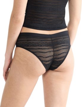 Czarne koronkowe majtki Sloggi Free Evolve Hipster Lace, półprzezroczyste, widok z tyłu na modelce.