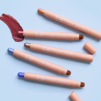 J.Cat Beauty Shimmie Struck Shadow Stick, zestaw 5 kremowych cieni w sztyfcie w różnych odcieniach, ze swatchami na jasnoniebieskim tle.