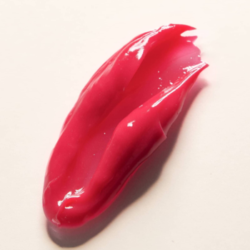 Błyszczący peptydowy balsam do ust Say Hi Glassy Lips Fuksja, różowa smuga na beżowym tle.