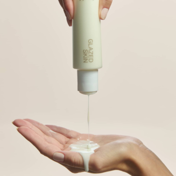 Mleczne serum Say Hi Glazed Skin w jasnej butelce, wylewane do dłoni, podkreśla płynną konsystencję.