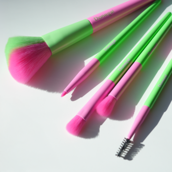 Zestaw 5 pędzli do makijażu Donegal Dopamine: różowe włosie, zielone rączki. Rozłożone na białym tle.