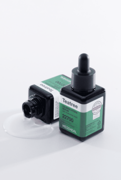 Dwie ciemne butelki Mediheal Teatree Calming Hydra Serum z kroplomierzami, jedna leży z rozlanym serum.