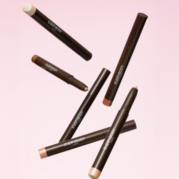 Kilka brokatowych cieni Everybody London Shimmer Pen w kredce, w odcieniach beżu i brązu, unosi się na różowym tle.