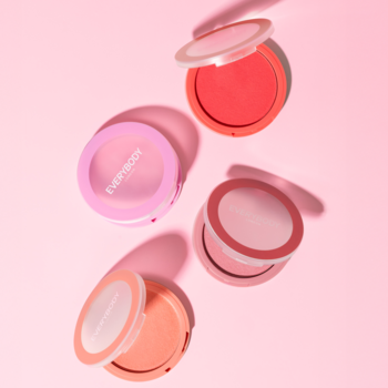 Cztery otwarte kremowe róże Everybody London (odcienie różu, brzoskwini, koralu) na różowym tle, widok z góry.