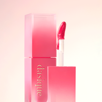 Zbliżenie na otwarty nawilżający błyszczyk Dasique Juicy Dewy Cherry Soda, różowy aplikator z produktem, gradientowa butelka.