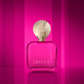 Woda perfumowana Shakira Fucsia w różowym, przezroczystym flakonie ze złotą nakrętką-słońcem na tle różowych pasów.