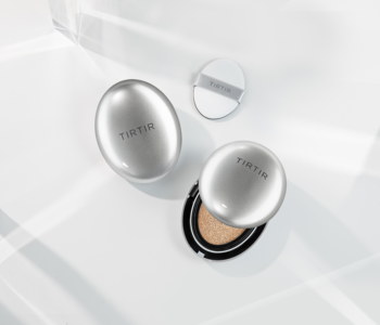 Srebrny, rozświetlający podkład TIRTIR Mask Fit Aura Cushion, otwarty i zamknięty, z aplikatorem, na białym tle.