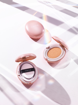 TIRTIR Mask Fit All Cover Cushion 51N Fudge, dwa różowe opakowania otwarte i jedno zamknięte na tle z tęczowymi refleksami.