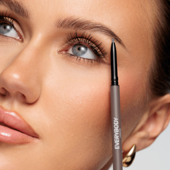 Kobieta aplikuje kredkę do brwi EVERYBODY Brow Definer Medium Brown ze szczoteczką. Zbliżenie na precyzję.