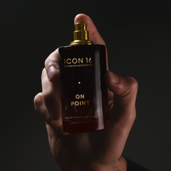 Męska woda perfumowana On Point ICON16 w ciemnej, prostokątnej butelce ze złotym atomizerem, trzymana w dłoni.