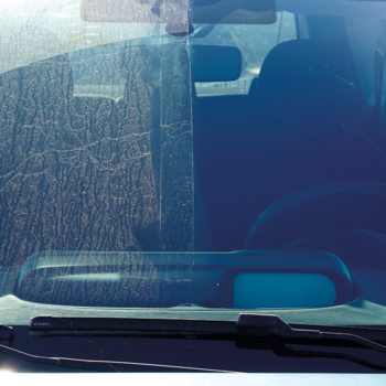 Przednia szyba samochodu: brudna i zapylona lewa strona kontra krystalicznie czysta prawa po umyciu.