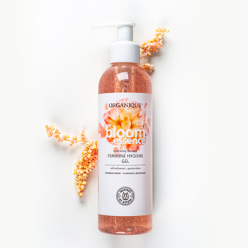 Organique Bloom Essence żel do higieny intymnej, różowy, w butelce z pompką, na białym tle, z suszonymi kwiatami.