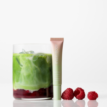 Balsam Peptide Lip Balm Raspberry Matcha w beżowo-zielonej tubce, obok matcha latte w szklance i maliny.
