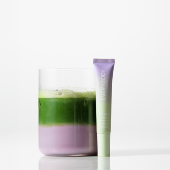 Peptydowy balsam do ust Lavender Matcha w zielonej tubce, obok szklanki z zielono-fioletowym napojem.