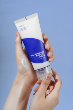 Żel-krem Isntree Hyaluronic Acid Aqua Gel Cream w biało-niebieskiej tubce, wyciśnięty na dłoń.