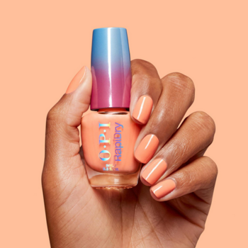 Szybkoschnący lakier OPI RapiDry Within Peach w dłoni, butelka z niebiesko-różową ombre zakrętką, paznokcie pomalowane.