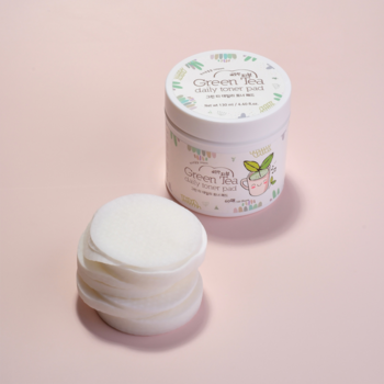 Esfolio Green Tea Daily Toner Pads: biały słoik i stos białych tonizujących płatków na różowym tle.